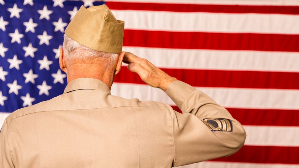 elderly veteran saluting American flag